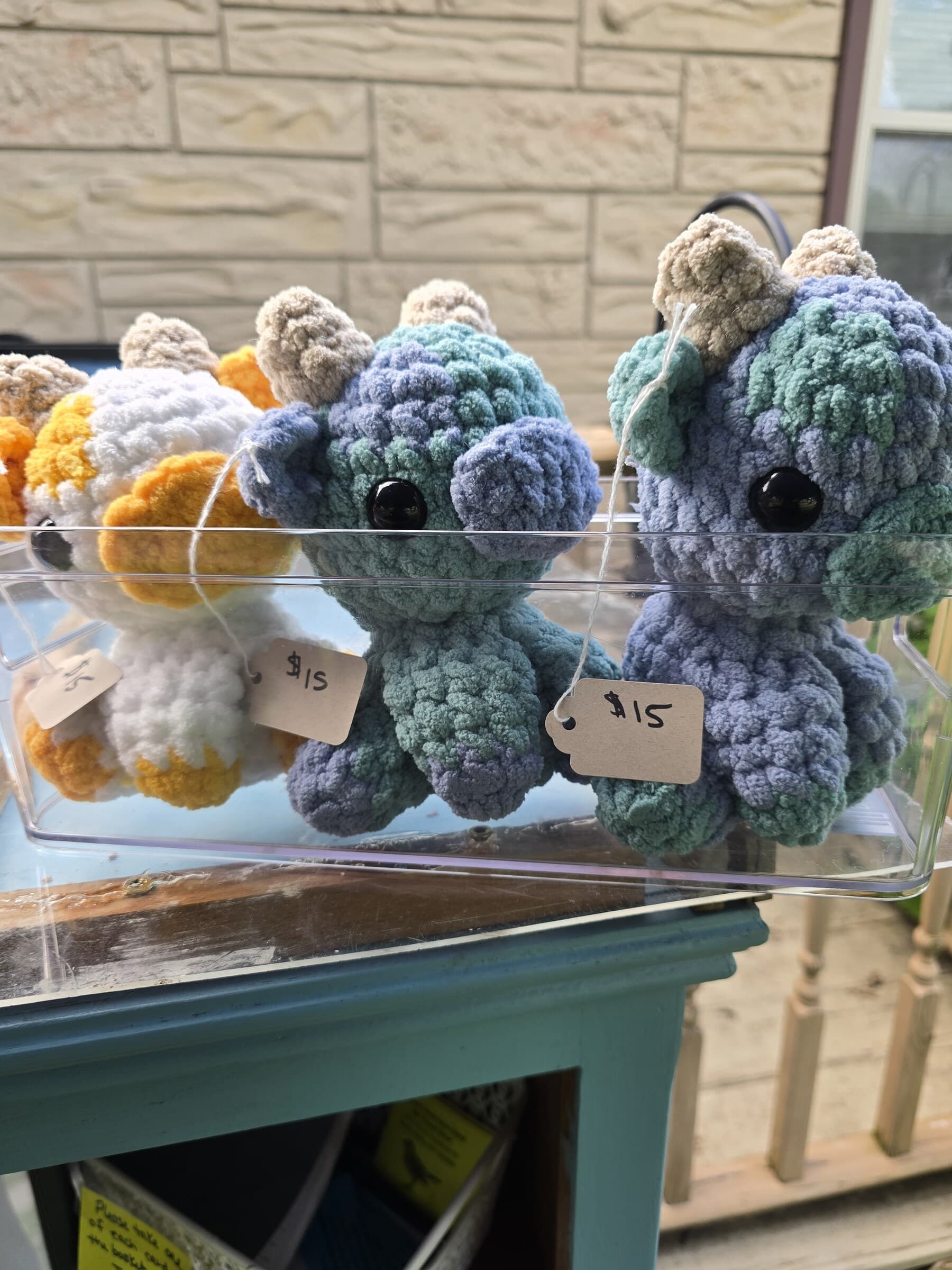 Blue and gray mini crocheted octopus plushies displayed at the farm stand.